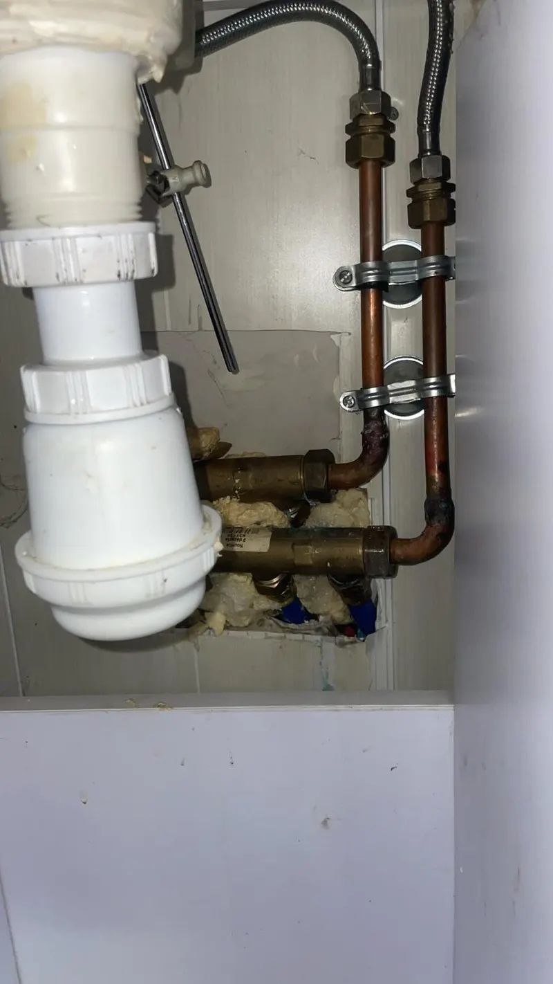 Siphon et raccords cuivre neufs sous un lavabo